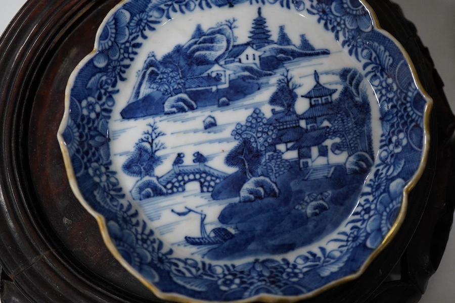 An 18th century Chinese blue and white dish, two jars (one without cover), a teapot and two carved wooden stands